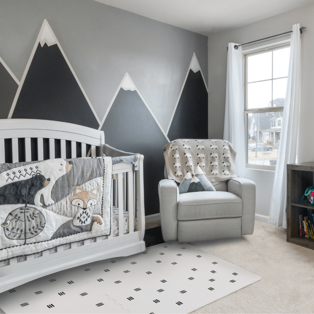 The White with black stripes play mat, set up in a child’s room with matching decor. 