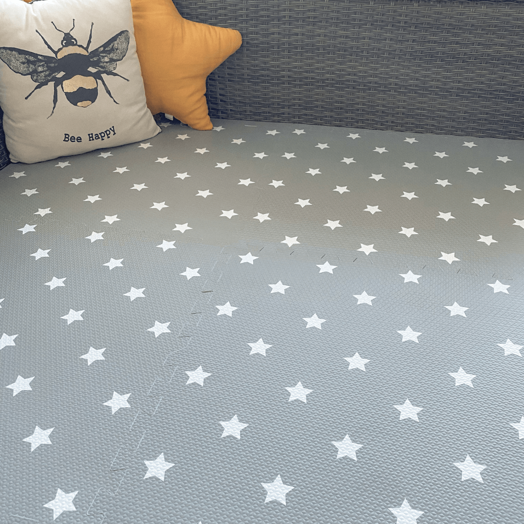 Grey with white stars play mat, set up in a play space in the home.