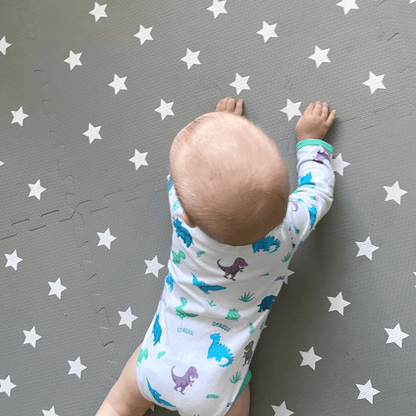 Baby practicing tummy time on the Grey with white stars play mat.