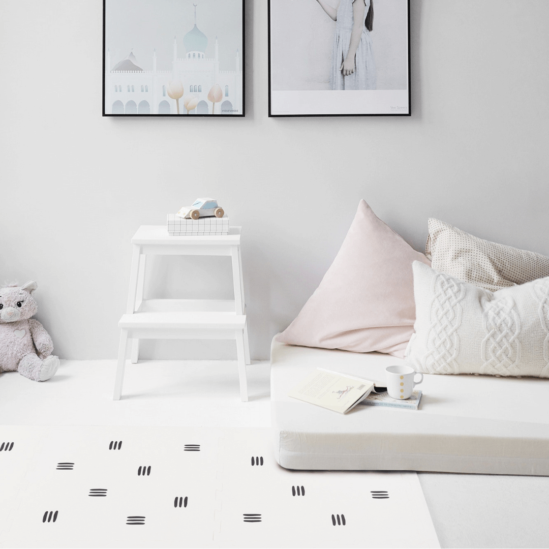 The White with black stripes play mat, set up in a child’s room from the Maxie and Moo luxury collection. 