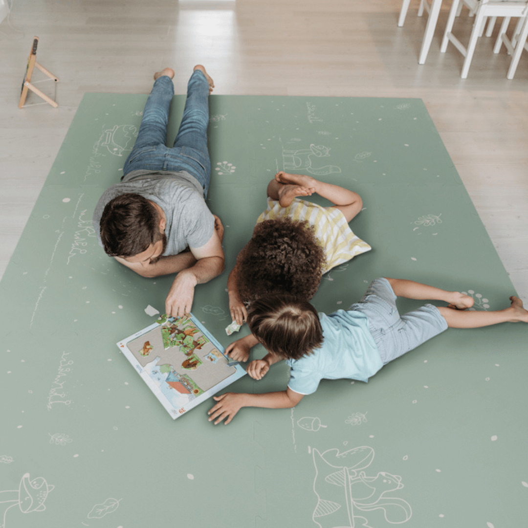 Fairytale Forest Mint Green Playmat being used by a dad and children. 