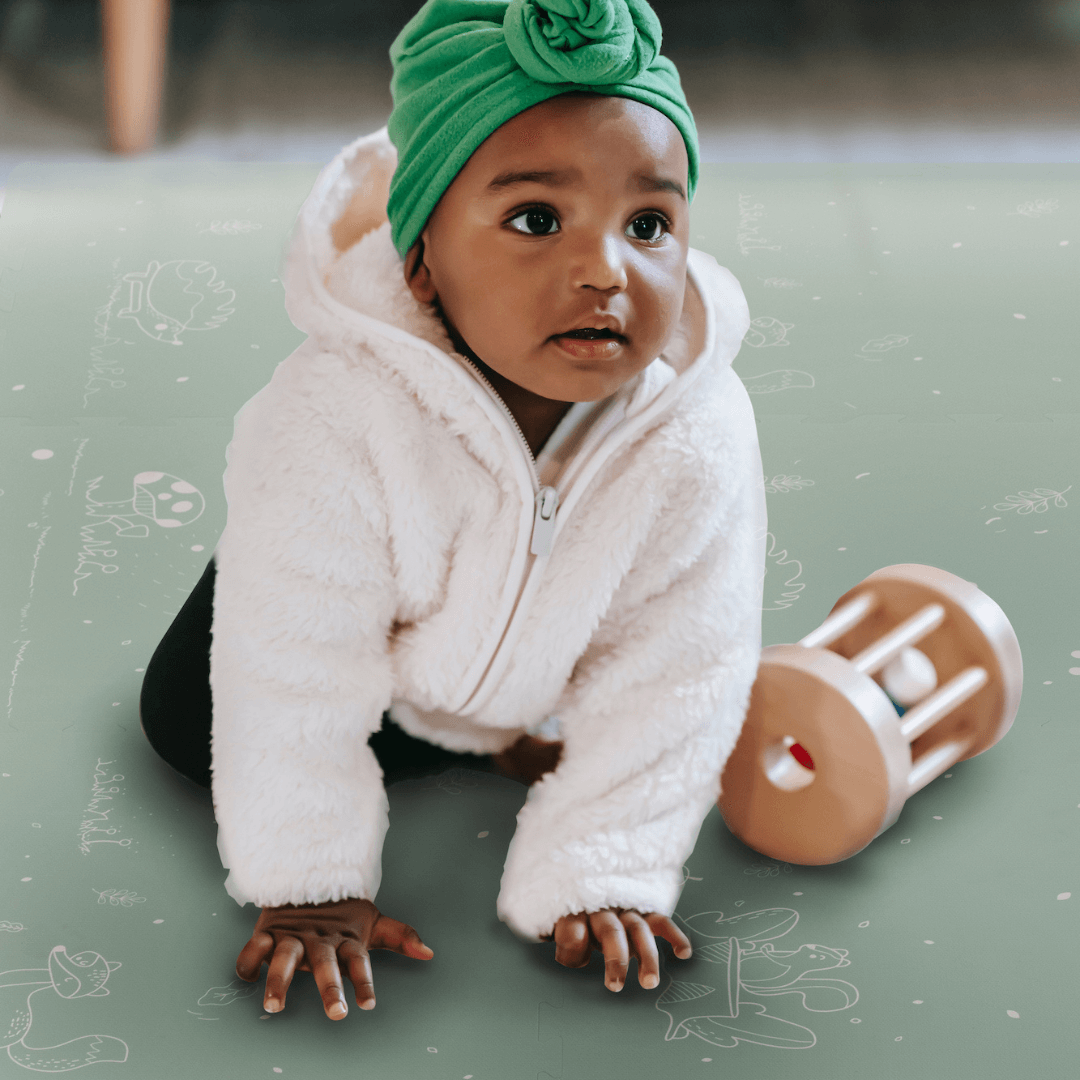 baby enjoying playtime on our luxury collection Fairytale Forest Mint Green Play Mat. The play mat is extra thick making play and tummy-time comfortable for baby