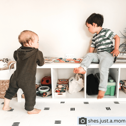 Children having fun playing on the White with black stripes play mat, set up in a child’s play space